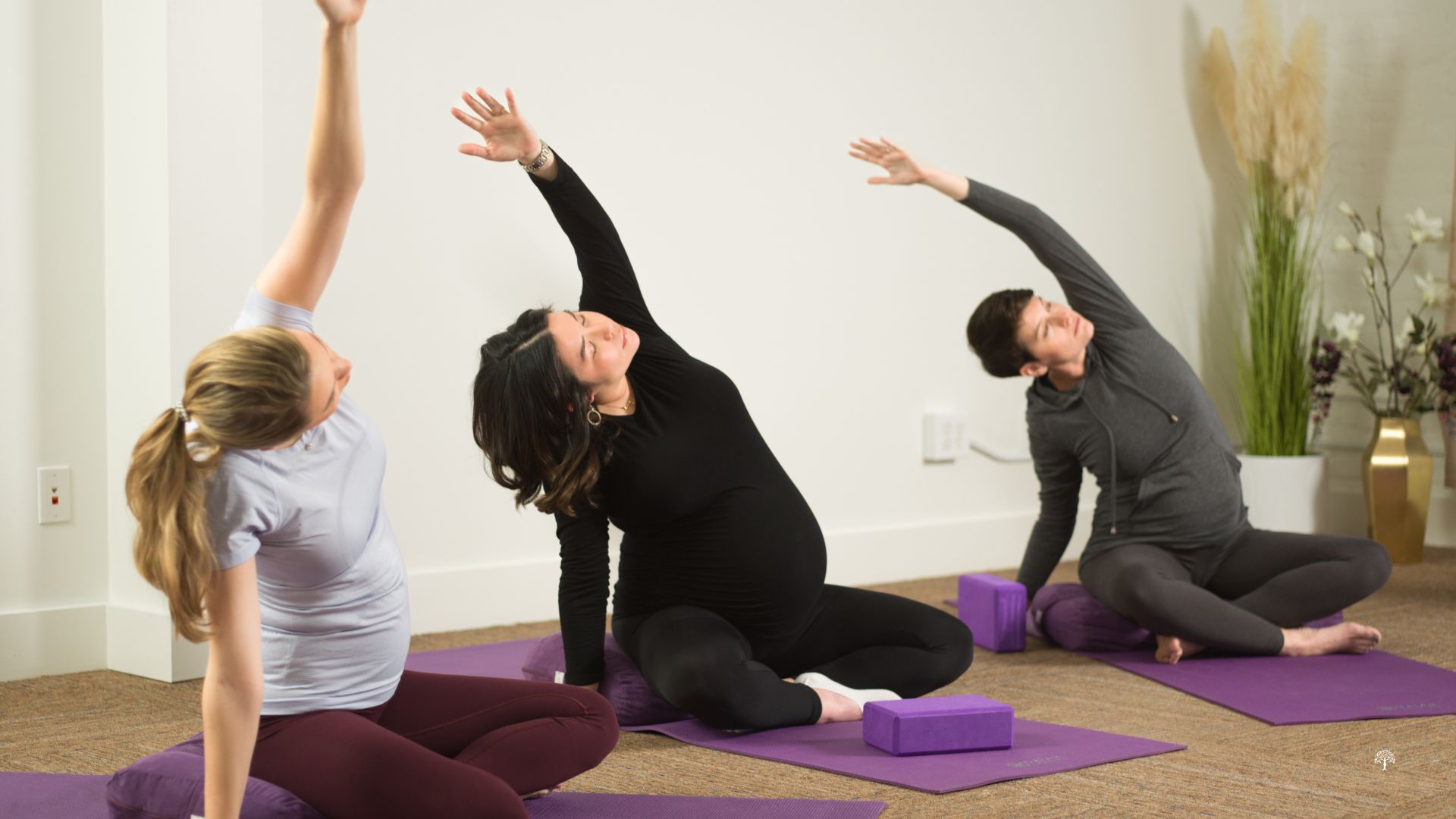 Group of pregnant women participating in a prenatal yoga class at Taylor Physical Therapy & Wellness in Winston-Salem, NC, practicing breathing and gentle poses for pregnancy wellness.