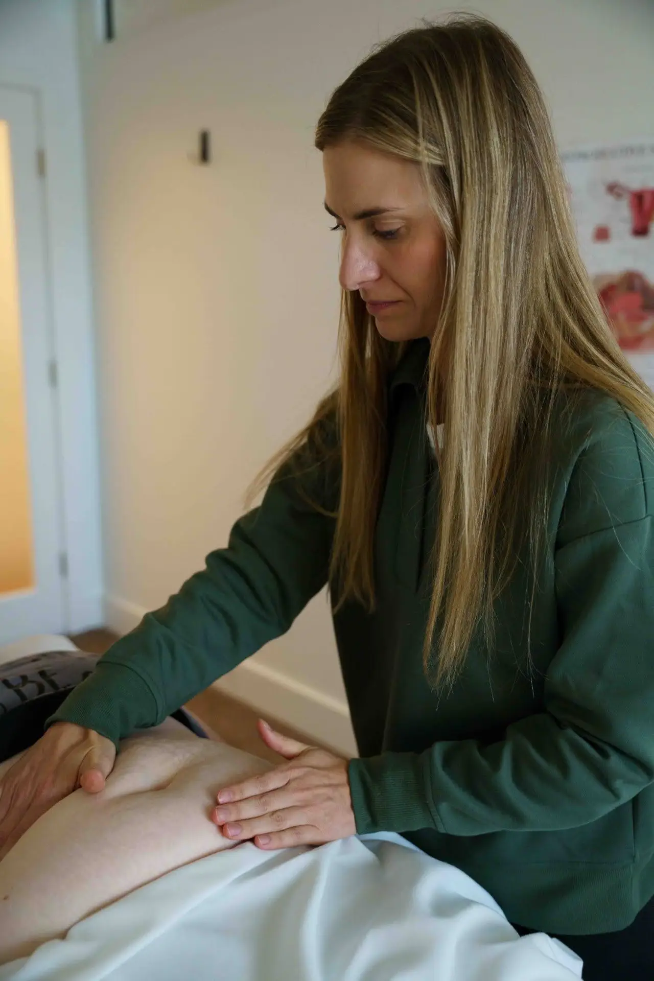 occupational therapist performing pelvic floor therapy hands-on treatment in a calm wellness clinic setting
