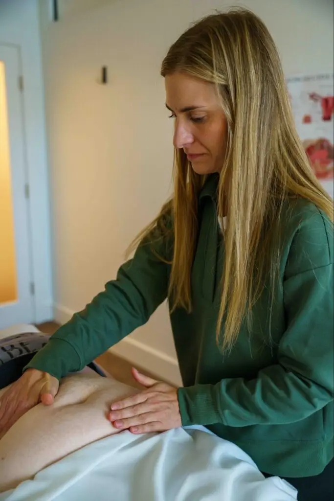 Pelvic floor physical therapist providing hands-on abdominal treatment