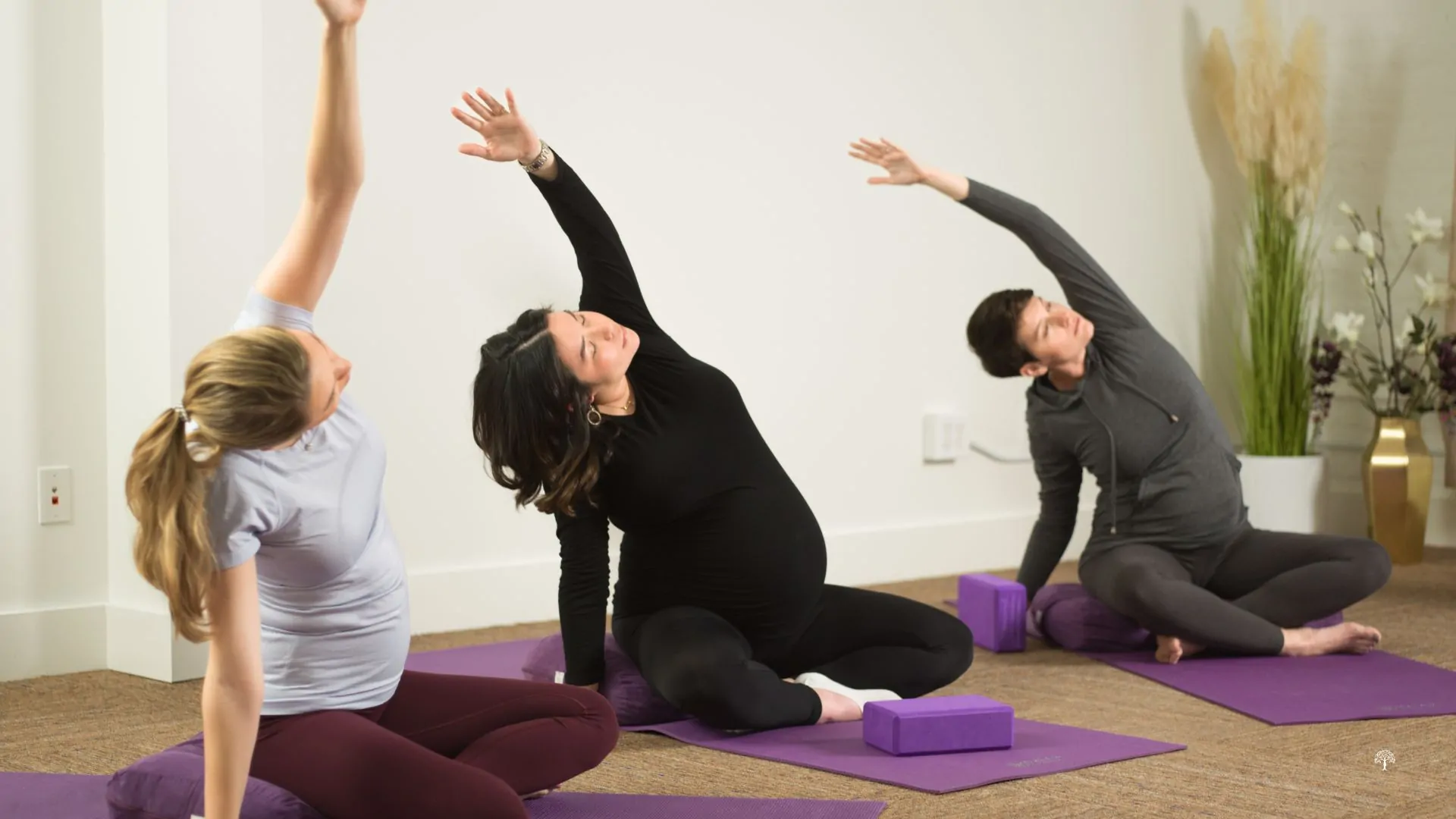 Group of pregnant women participating in a prenatal yoga class at Taylor Physical Therapy & Wellness in Winston-Salem, NC, practicing breathing and gentle poses for pregnancy wellness.